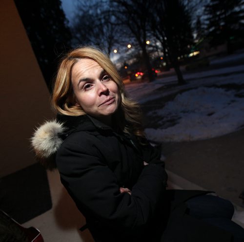 Marta Vodrey sits on her front step shrugging, she had a package, containing four custom-designed photo albums of family vacation photos and delivered by Canada Post, stolen from her doorstep last Wednesday. See Ashley Prest story. December 15, 2015 - (Phil Hossack / Winnipeg Free Press)