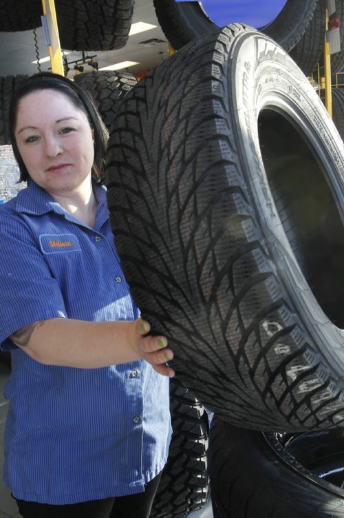 Melissa Farrell,  Administrator at  Kal Tire 1777 Brookside Boulevard with a winter tire.The story is on MPI's Winter Tire program. Scott Billeck (intern) story Wayne Glowacki / Winnipeg Free Press Dec.16 2014