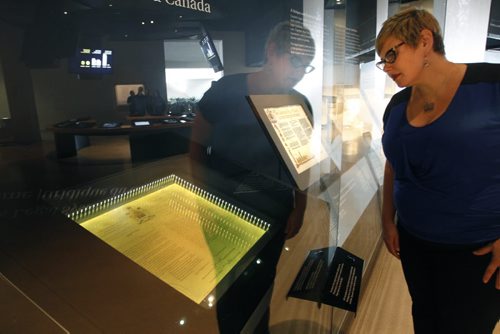 Heather Bidzinski, Head of Collections at the Canadian Museum for Human Rights with at left the 1982 Proclamation of the Constitution document behind glass and light protected smart glass technology so the document is protected from excessive light, preserving the ink signatures from degradation.  The CMHR is displaying the  rarely loaned, historic documents from Library and Archives Canada in the Protecting Rights in Canada gallery. Ashley Prest story Wayne Glowacki / Winnipeg Free Press Dec.17 2014