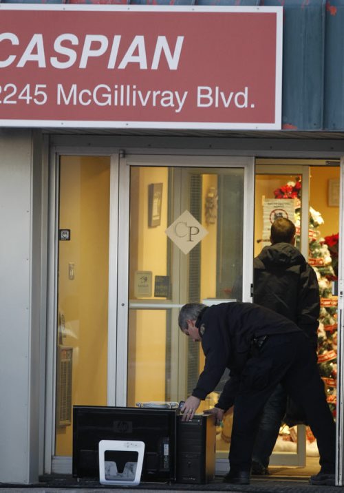 Members of the RCMP return some computer equipment to Caspian on McGillivray Blvd. during the continuing investigation Thursday morning. Wayne Glowacki / Winnipeg Free Press Dec.18 2014