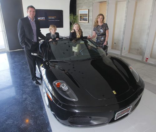 Trevor Nott with his family l-r Jack, Ella, and wife Amber. Missing is his son Carter who is on a school ski trip. The group posed with a Ferrari F430 Spider in the new under construction showroom at the corner of McGillivray and Waverly. BORIS MINKEVICH /WINNIPEG FREE PRESS. December 18, 2014
