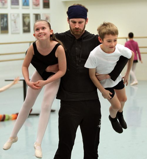 RWB dancer Liam Caines carries off two of his charges in a rehearsal studio Thursday evening to begin another run through of RWB's "Nutcracker". See Story. December 18,2014 - (Phil Hossack / Winnipeg Free Press)
