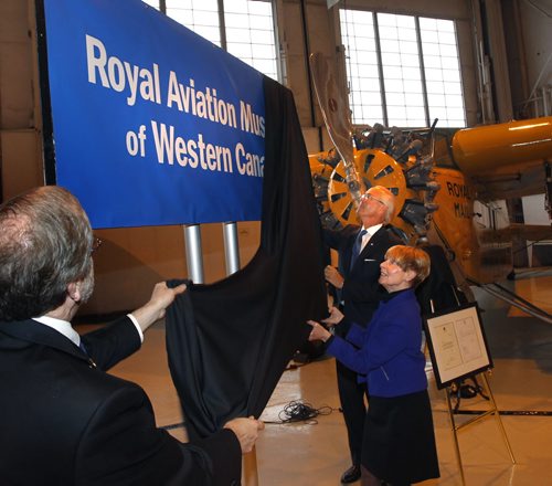 From left, Bruce Emberley, pres. of the Board, Shirley Render, ex. dir. of the Western Canada Aviation Museum and Hartley Richardson, friend of the Museum unveil the banner Friday renaming the museum to the "Royal Aviation Museum of Western Canada". Intern has the story. Wayne Glowacki / Winnipeg Free Press Dec.19 2014