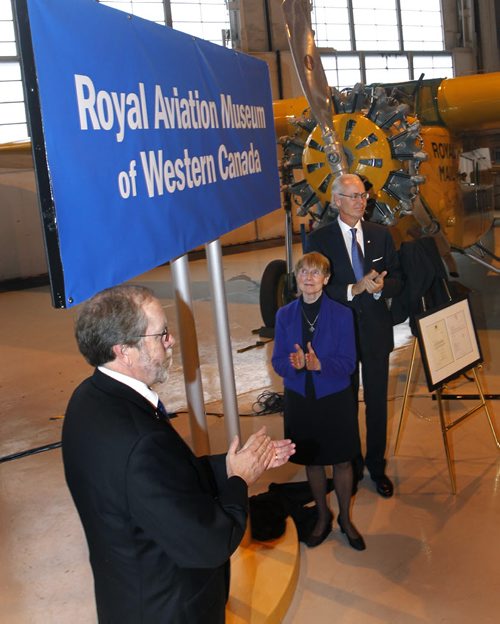 From left, Bruce Emberley, pres. of the Board, Shirley Render, ex. dir. of the Western Canada Aviation Museum and Hartley Richardson, friend of the Museum unveil the banner Friday renaming the museum to the "Royal Aviation Museum of Western Canada". Intern has the story. Wayne Glowacki / Winnipeg Free Press Dec.19 2014