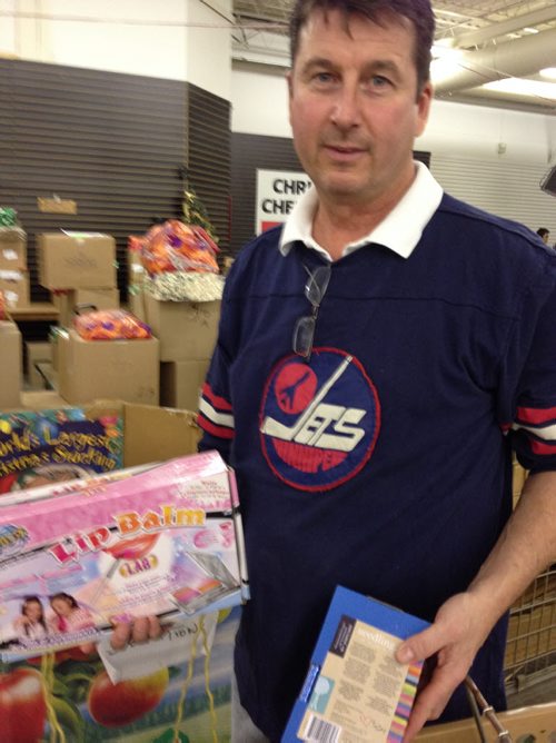 Volunteer Kirk Luke loads toys into a cart. - Christmas Cheer Board - December 18, 2014  Alexandra Paul / Winnipeg Free Press