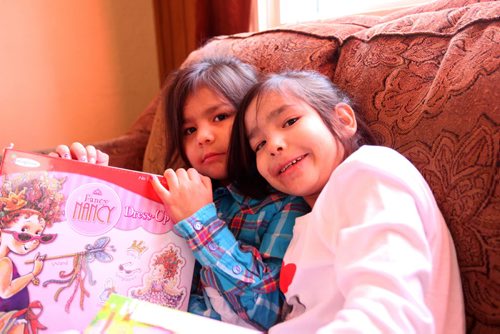 Seven-year-old Dreanna Sinclair (right) and her little sister Shaelynn  - 5yrs, are all smiles after opening gifts they just received from Ma Mawi Wi Chi Itata Centre's 12th Annual Christmas Hamper Drive which took place at R.B. Russell School Saturday morning.     See story.  Dec 20,  2014 Ruth Bonneville / Winnipeg Free Press
