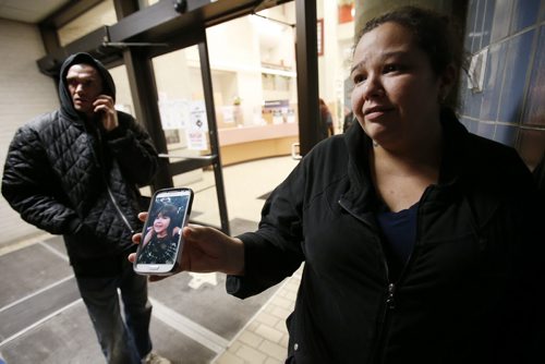 December 23, 2014 - 141223  -  Stephanie Bradley, whose mother Marlene Pelletier was killed and her children injured in a car collision, returned home to find that someone had broken in and stolen christmas gifts and money. Bradley looks at a photo of her daughter Luna Rae as she and her friend Will Philippot talk to media outside HSC Tuesday, December 23, 2014.  John Woods / Winnipeg Free Press