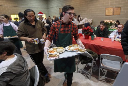 Stdup Local . Ziggy Linklater a first year volunteer  is one of many volunteers serving .AGAPE Table is serving 400 turkey dinners with all the trimmings and pumpkin pie Wed. morning , Santa is also visiting and everyone will reciev a Christmas present . Dec. 24 2014 / KEN GIGLIOTTI / WINNIPEG FREE PRESS