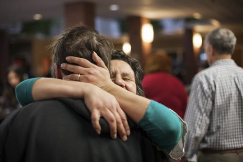 Diana Chartrand embraces her partner Bill Trnka before a Christmas Day meal at the West Broadway Community Ministry. Dec. 25, 2014  Jesse Winter / Winnipeg Free Press