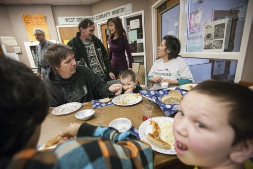 Diana Chartrand (far right) chats with friends while sharing a meal with her partner Bill Trnka (seated, left) and her five children at the West Broadway Community Ministry. Dec. 25, 2014. Jesse Winter / Winnipeg Free Press