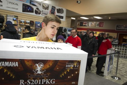 Graham Lalonde carries a sound system for a customer at the Advance Electronics Boxing Day sale in Winnipeg. Dec. 26, 2014. Jesse Winter / WInnipeg Free Press