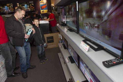 Kaden Slobodzian and his father John checked out a TV that Kaden said he wants for his bedroom. Dec. 26, 2014. Jesse Winter / WInnipeg Free Press