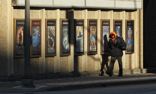 A pedestrian walks by the Towne Theatre as the sun slowly rises Sunday morning.  141228 December 28, 2014 Mike Deal / Winnipeg Free Press