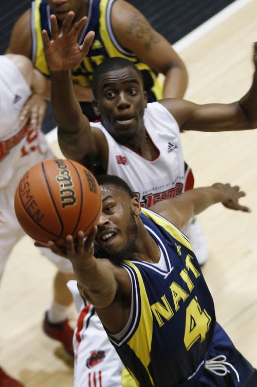 December 28, 2014 - 141228  - NAIT's Alvin Parker (4) goes up for two against University of Winnipeg's Jelane Pryce (7) in the university semi-final game in the Wesmen Classic at the University of Winnipeg Sunday, December 28, 2014.  John Woods / Winnipeg Free Press