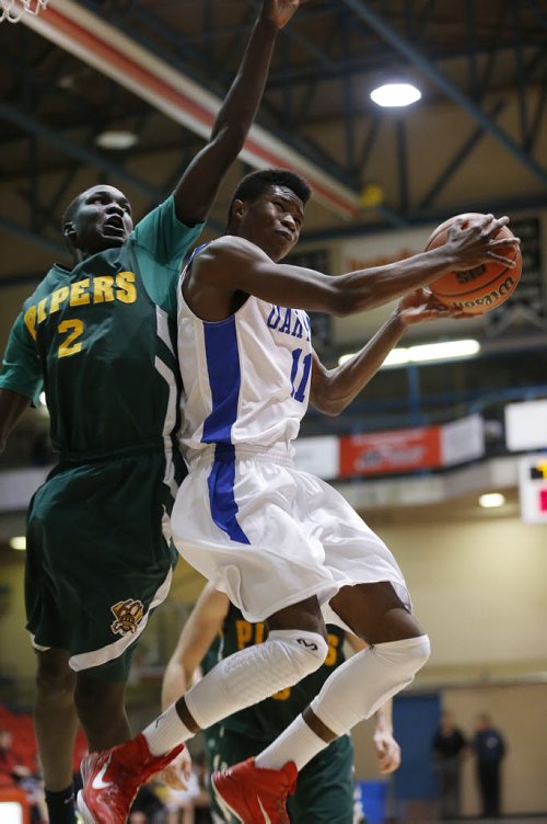 December 28, 2014 - 141228  - Oak Park Raiders William Sesay (11) goes up for two against John Taylor Pipers Louis Makot (2) in the high school semi-final game in the Wesmen Classic at the University of Winnipeg Sunday, December 28, 2014.  John Woods / Winnipeg Free Press