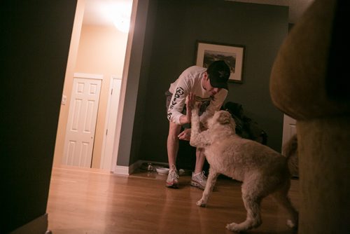 6:08:24 AM Just after 6 a.m., the kids still in bed and wife Tracey out on an icy run, Brian feeds his eight-year-old Labradoodle Indiana, who high-fives on command before he eats his breakfast.   141215 - Monday, December 15, 2014 - (Melissa Tait / Winnipeg Free Press)