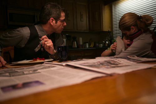 7:00:00 AM Brian reads the day's newspapers and eats a breakfast of leftover pancakes and fruit, while Austin slowly wakes up.  141215 - Monday, December 15, 2014 - (Melissa Tait / Winnipeg Free Press)