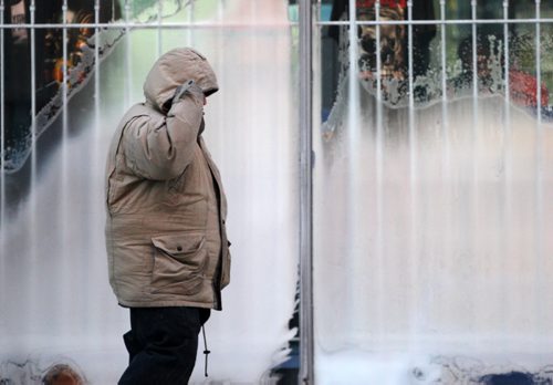 Chilly Morning- A passerby cover his face from the extreme temperatures of -30c in downtown Winnipeg Monday morning - Chilly winds have seen Environment Canada to issue a Extreme Cold warning in effect-standup photo  Dec 29, 2014   (JOE BRYKSA / WINNIPEG FREE PRESS)