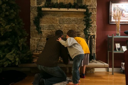 7:01:56 PM The boys know help prepare the fireplace to make the fire.  141215 - Monday, December 15, 2014 - (Melissa Tait / Winnipeg Free Press) Brian Bowman