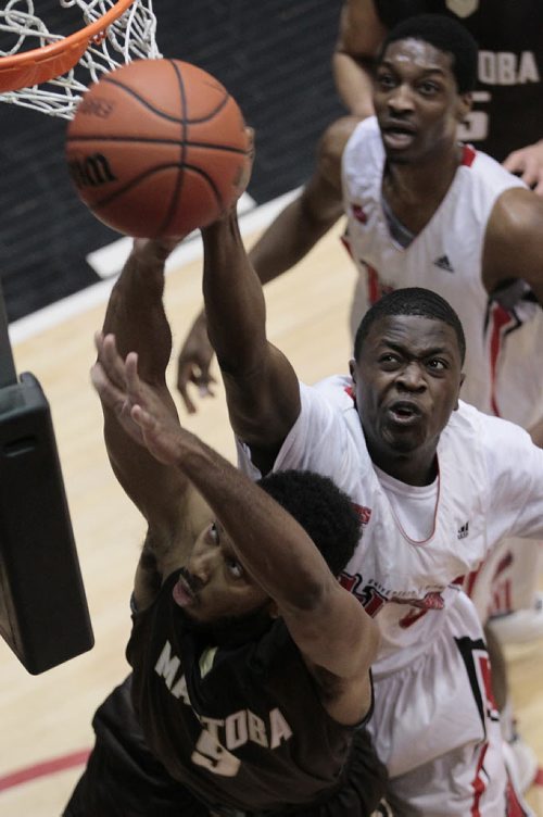 December 28, 2014 - 141228  - University of Winnipeg's Denzel Lynch-Blair (0) attempts to stop University of Manitoba's Jonathan Medrano (9) as he goes for the two pointer in the Wesmen Classic at the University of Winnipeg Monday, December 29, 2014.  John Woods / Winnipeg Free Press
