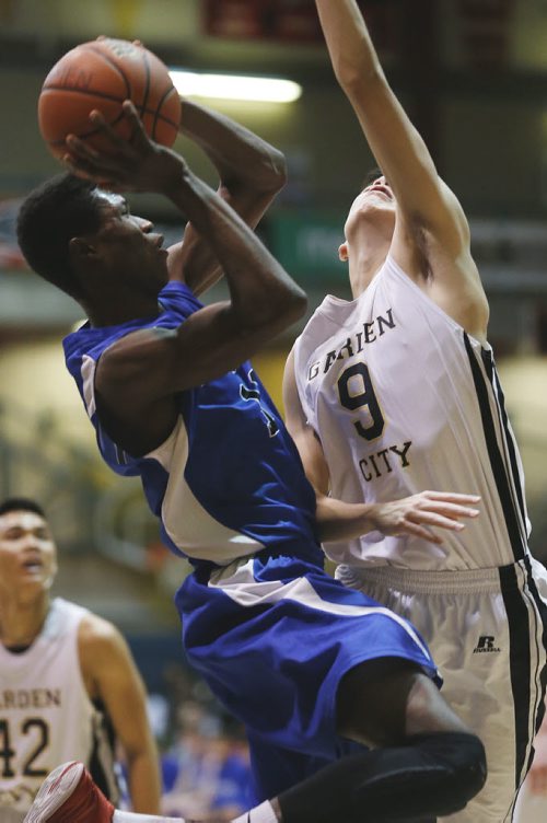 December 30, 2014 - 141230  - Oak Park Raiders' William Sesay (11) goes up for two against Garden City Fighting Gophers' Trezon Morcilla (9) in the high school final game in the Wesmen Classic at the University of Winnipeg Tuesday, December 30, 2014.  John Woods / Winnipeg Free Press