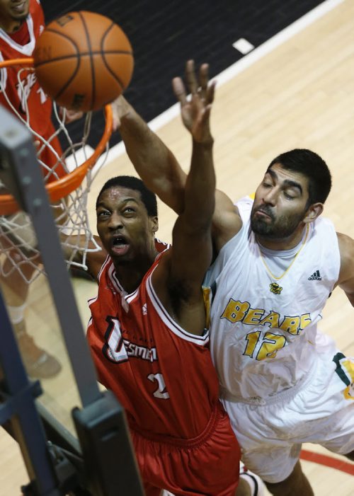 December 30, 2014 - 141230  - University of Alberta's Rav Dhaliwal (12) goes up for two as University of Winnipeg's Mark McNee (2) attempts the block in university final game action in the Wesmen Classic at the University of Winnipeg Tuesday, December 30, 2014.  John Woods / Winnipeg Free Press