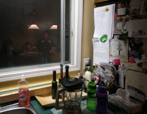 7:19:35 PM The family at dinner reflected in the steamy kitchen window. 141215 - Monday, December 15, 2014 - (Melissa Tait / Winnipeg Free Press) Brian Bowman