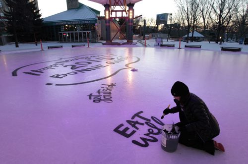 Local artist Kal Barteski begins painting New Years resolutions on the ice rink under the canopy at The Forks¤Wednesday morning. Adam Wazny  story  Wayne Glowacki / Winnipeg Free Press Dec.31 2014
