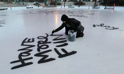 Local artist Kal Barteski begins painting New Years resolutions on the ice rink under the canopy at The Forks¤Wednesday morning.\¤Adam Wazny  story  Wayne Glowacki / Winnipeg Free Press Dec.31 2014
