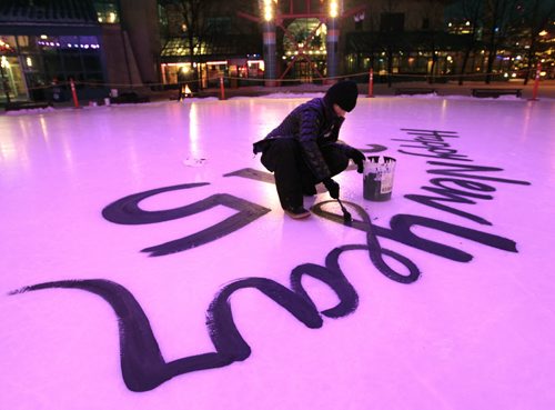 Local artist Kal Barteski begins painting her messages that will include New Years resolutions on the ice rink under the canopy at The Forks¤Wednesday morning.\¤Adam Wazny  story  Wayne Glowacki / Winnipeg Free Press Dec.31 2014