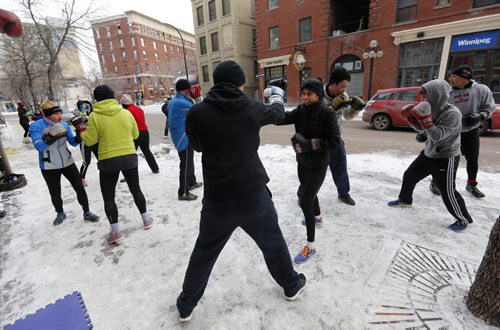 Stdup . (Centre left) back Dylan Martin spars with (right centre) Priyanka Dhillon . Pan Am Boxers , Take it Outside with the First Annual Polar Boxing workout , something different for the 30 boxers at the Exchange club to do to mark the end of 2014 and the beginning of 2015. The one hour high intensity work took place with sparing , calisthenics , cycling and running .  Dec. 31 2014 / KEN GIGLIOTTI / WINNIPEG FREE PRESS