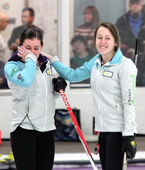 Beth Peterson (skip) wipes her eyes with a smiling Robyn Njegovan (third) after winning the Junior Women's Provincial Championship at the Assiniboine Memorial Curling Club Wednesday evening.  141231 December 31, 2014 Mike Deal / Winnipeg Free Press