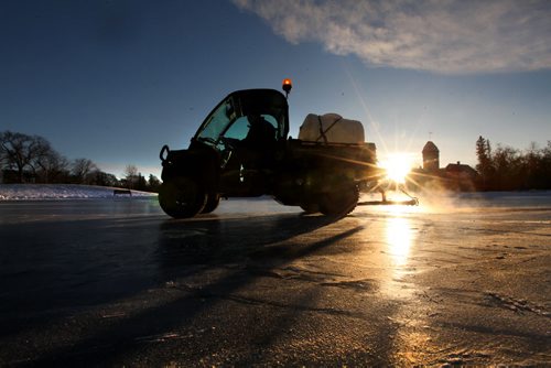 Assiniboine Park Grounds Keeper Bob Turcotte floods the Duck Pond Saturday morning as the sun peaks its head over the horizon for the first time in 2015 at the start of a new year.  Standup photo  Jan 01, 2015 Ruth Bonneville / Winnipeg Free Press