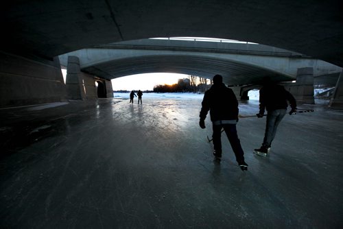 Skaters make their way under the Queen Elizabeth Way Bridge heading southwest along the Red River on the River Trail on its opening day Thursday in the late afternoon.   Jan 01, 2015 Ruth Bonneville / Winnipeg Free Press