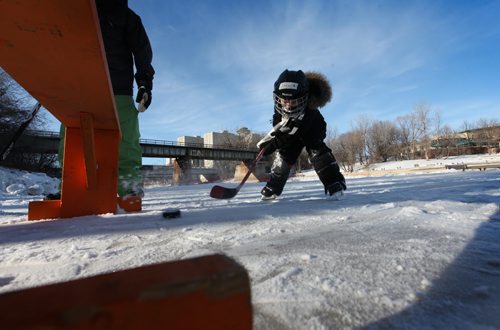 Four-year-old Jack Springer didn't seem to mind the cold as he plays hockey on the new rink on the Assiniboine River Thursday with his dad.    Jan 01, 2015 Ruth Bonneville / Winnipeg Free Press