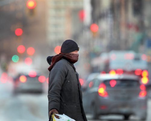 Bitter Cold Continues- A passerby crosses Portage Ave at Carlton during a bitter cold Monday morning in Winnipeg. - Environment Canada has just lifted the Extreme cold warning for Winnipeg this morning but cold conditions will continue.-standup photo  Jan 05, 2015   (JOE BRYKSA / WINNIPEG FREE PRESS)