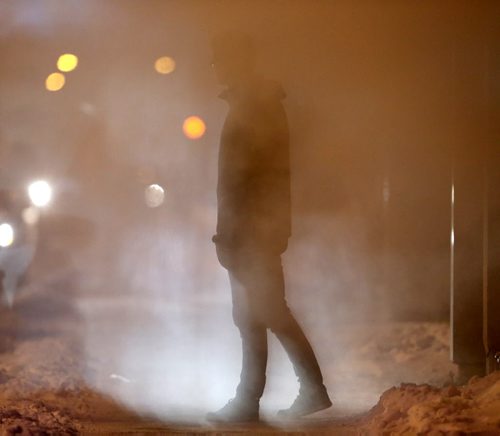 Jared Thompson stands in a steam vent on Smith Street near York Avenue while waiting for a ride to pick him up, Wendesday, January 7, 2015. (TREVOR HAGAN/WINNIPEG FREE PRESS)