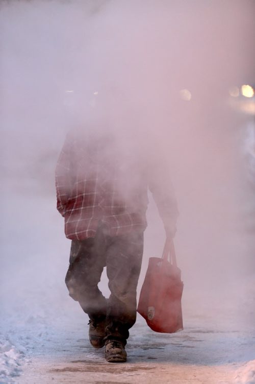 A man emerges from steam from a vent on Smith Street near York Avenue, Wendesday, January 7, 2015. (TREVOR HAGAN/WINNIPEG FREE PRESS)