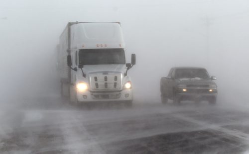 A pickup passes a parked tractor trailer waiting for conditions to clear and open the Trans Canada Highway at Headingly Thursday afternoon. Blowing snow was the cause of at least one accident between two tractor trailers and a pickup between Portage and Headingly on the Trans Canada before the section of highway was closed to traffic due to poor conditions. January 8, 2015 - (Phil Hossack / Winnipeg Free Press)