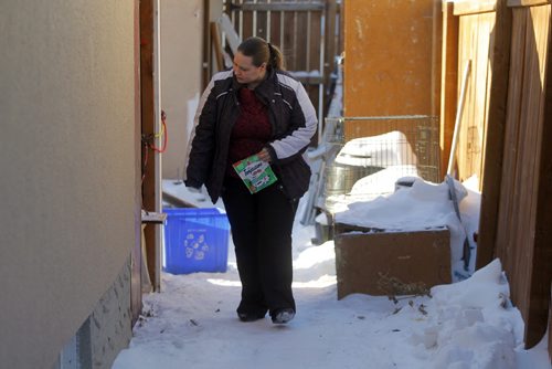 LOCAL NEWS - Carrie Muth lives in East Elmwood and feeds feral cats that live in an derelict garage next door. She said that Animal Services came to her door this week to check things out. Here Muth looks for the cats on her yard. BORIS MINKEVICH /WINNIPEG FREE PRESS. January 9, 2015