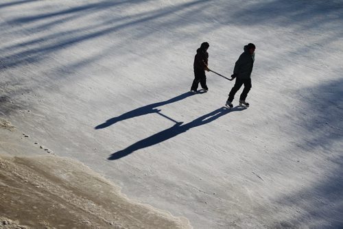 A father pulls a youngster along the ice with a hockey stick as they skate on the River Trail Saturday afternoon at the Forks.   Jan 10, 2015 Ruth Bonneville / Winnipeg Free Press