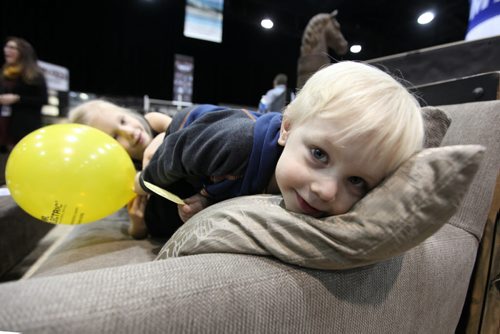 Three-year-old Andrew Carlson checks out the softness of a pillow and couch with his sister Jocelyn - 6-years, at the Wicker World Display  while attending the Kitchen & Bath Show at the Convention Centre with family Saturday.   Standup photo Jan 10, 2015 Ruth Bonneville / Winnipeg Free Press