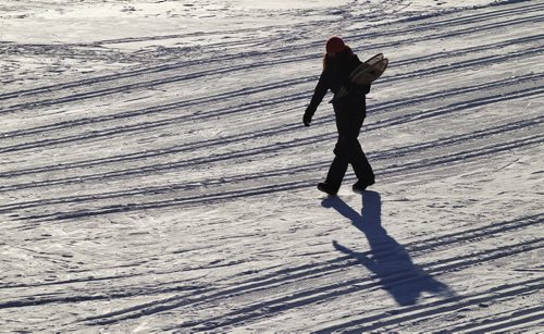 Christina Miller walks across one of the lakes after an afternoon of snowshoeing with her kids at Fort Whyte Alive Sunday. 150111 January 11, 2015 Mike Deal / Winnipeg Free Press