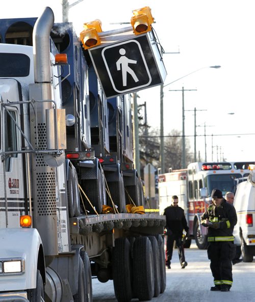 Winnipeg Fire Fighters at the scene on Silver Ave. Monday afternoon after a simi-trailer's load removed the crosswalk light standard at Hampton St. The incident closed east bound lanes on Silver  Ave.   Wayne Glowacki / Winnipeg Free Press ¤Jan. 12 2015