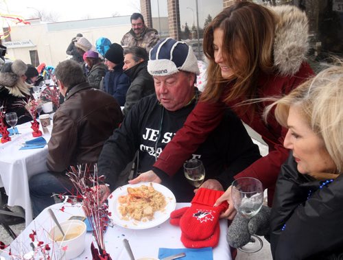 Raquel Sineiro a volunteer of Gus & Tonys at the Park ( 2015 Portage Ave)- serves Lobster Bisque Soup and Seafood Rice at the annual Polar Bear outdoor Lunch to Jean Louis Danguy - Gus & Tonys at the Park donate the food proceeds will go to Manitoba Theater for Young People - Jan 13, 2015   (JOE BRYKSA / WINNIPEG FREE PRESS)