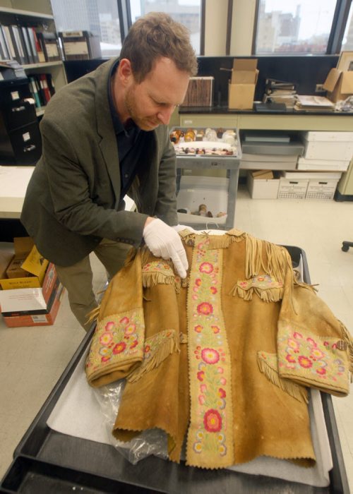 Roland Sawatzky, Curator of History at The Manitoba Museum with E. Cora Hind Moose hide jacket circa- 1926- The museum is looking for more artifacts from the first time women had the right to vote in 1916 for new exhibit.   The Manitoba Museum is creating a travelling exhibit to commemorate the 100th anniversary of Manitoba becoming the first province to extend the vote to women.- Jan 13, 2015   (JOE BRYKSA / WINNIPEG FREE PRESS)E