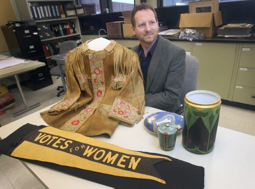 Roland Sawatzky, Curator of History at The Manitoba Museum with E. Cora Hind Moose hide jacket circa- 1926- other artifacts and a felt pennant circa 1915 which was found at a River Heights garage sale in the 70s- The museum is looking for more artifacts from the first time women had the right to vote in 1916 for new exhibit.   The Manitoba Museum is creating a travelling exhibit to commemorate the 100th anniversary of Manitoba becoming the first province to extend the vote to women.- Jan 13, 2015   (JOE BRYKSA / WINNIPEG FREE PRESSE