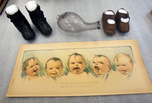 Baby painting by C H Twelvetrees and baby shoes and bottle from 1910s- The museum is looking for more artifacts from the first time women had the right to vote in 1916 for new exhibit.   The Manitoba Museum is creating a travelling exhibit to commemorate the 100th anniversary of Manitoba becoming the first province to extend the vote to women.- Jan 13, 2015   (JOE BRYKSA / WINNIPEG FREE PRESS)