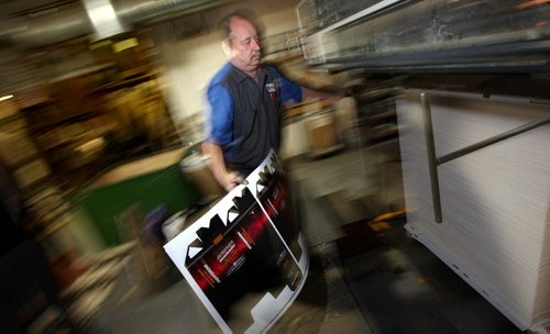 Press Room manager Colin Macauley pulls a printed box off the presses at  Selkirk based Sterling Packaging's facility. Kirbyson story. January 13, 2015 - (Phil Hossack / Winnipeg Free Press)