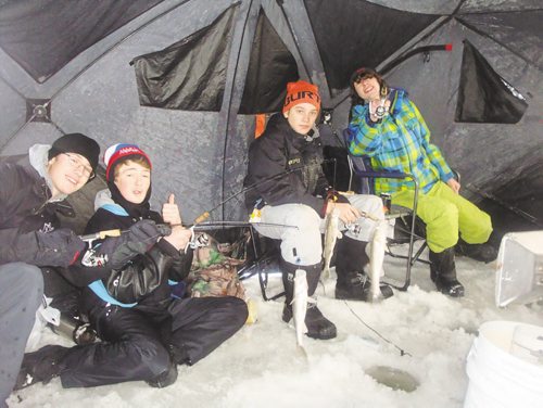 Canstar Community News Jan. 8, 2015 - Ethan Shuttleworth, Zachary Bennett, Hudson Wall, and Ryan Porio of River East Collegiate enjoying the shelter from the wind during the grade 9 outdoor education ice fishing trip to Lockport, Man.